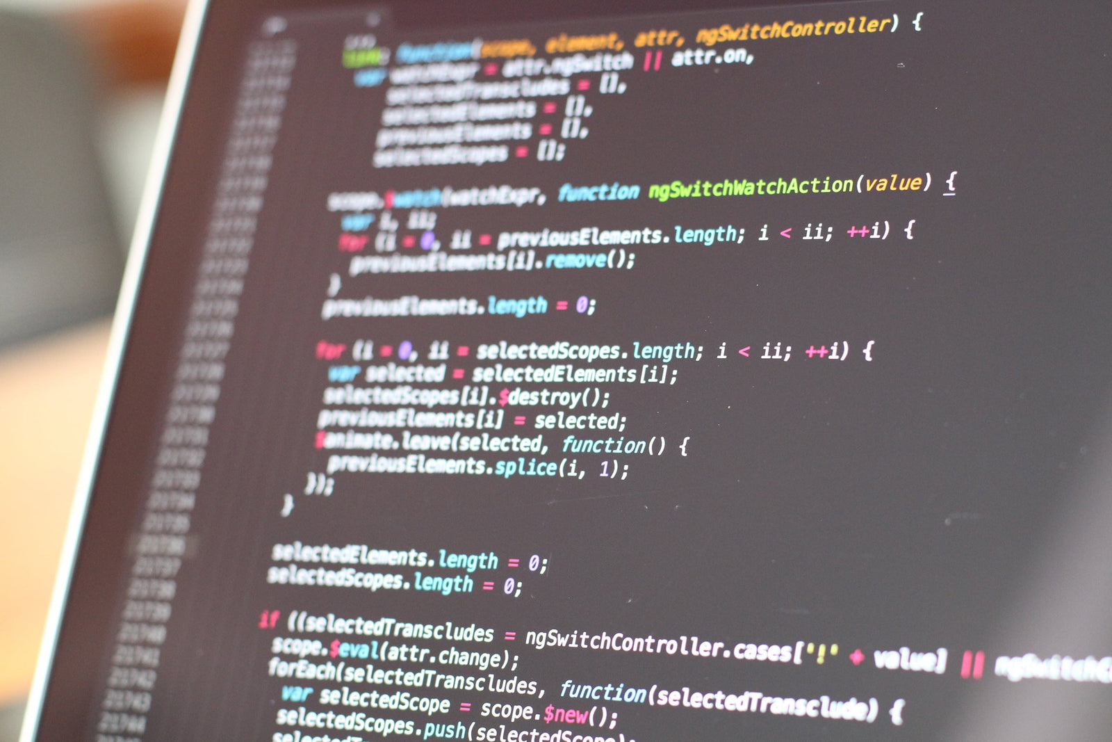 Close-up of computer code displayed on a dark screen, featuring JavaScript functions with syntax highlighting in blue, pink, and white text.